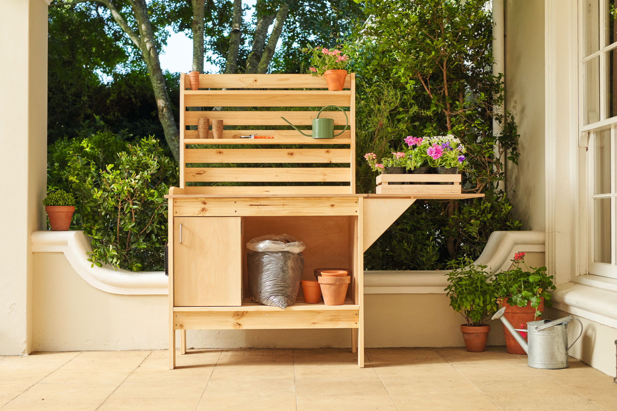 Houten plantentafel met bloempotten op de veranda