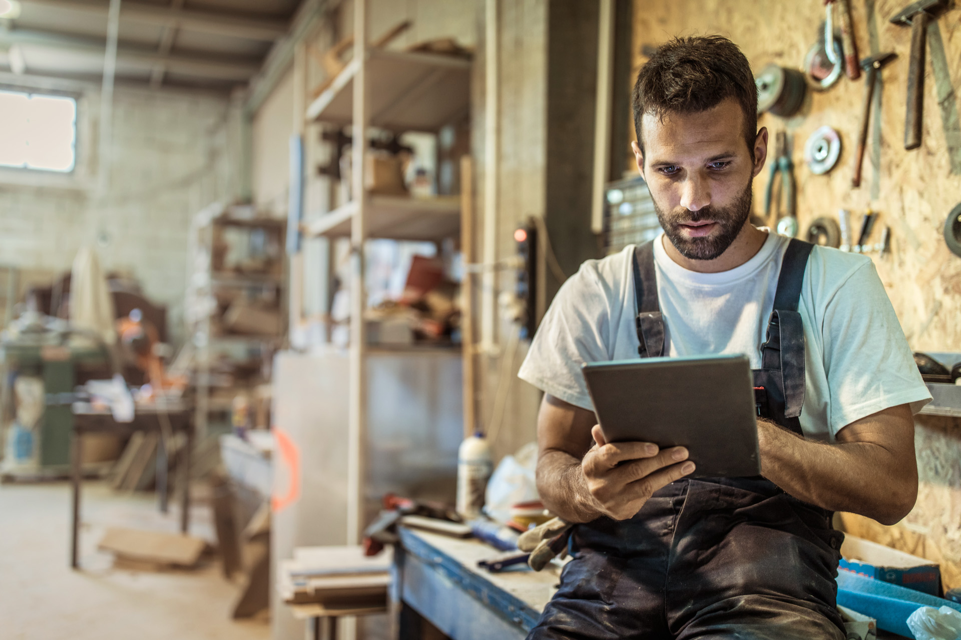 Een dealer gebruikt een keuzehulp op een tablet in een werkplaats om STIHL producten en accessoires te vinden.