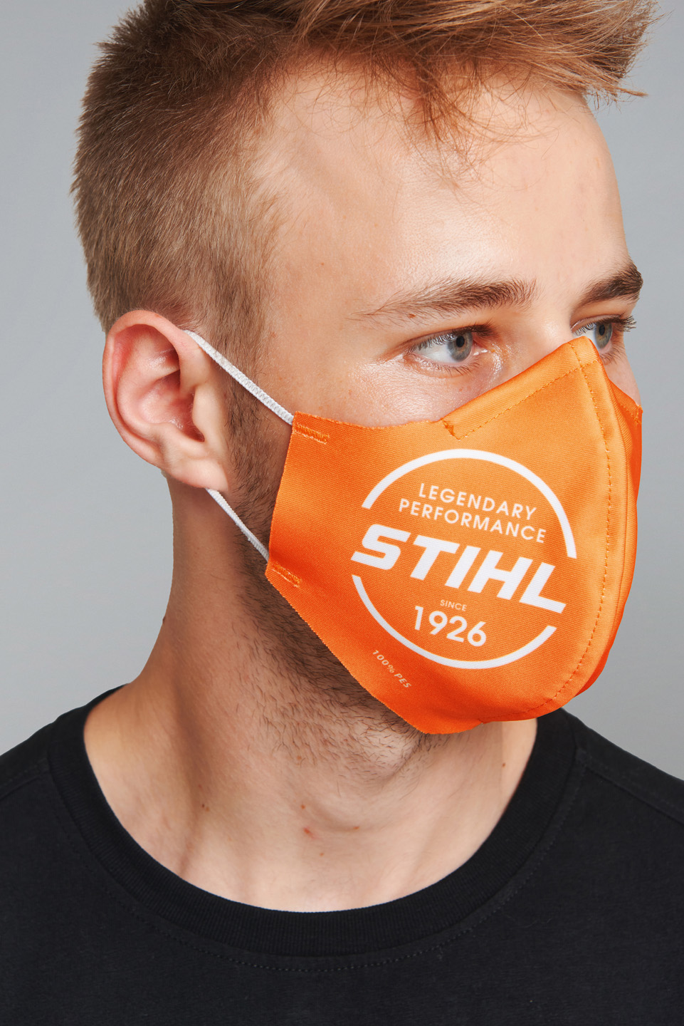 Mannelijk model draagt een oranje STIHL gezichtsmasker.