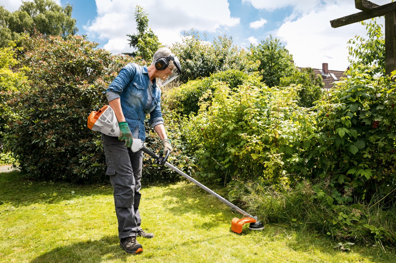 Vrouw maait kanten in de tuin met een FS 56 kantenmaaier op benzine