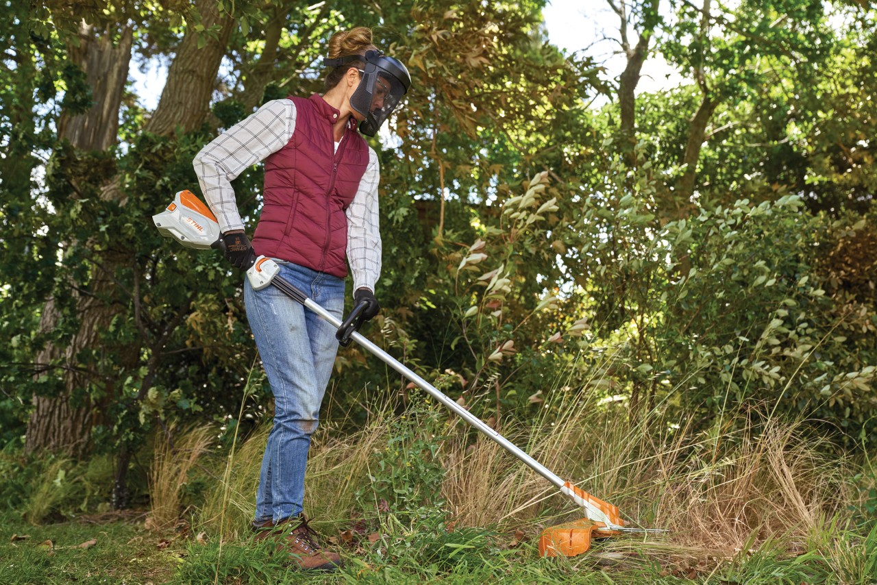 Vrouw maait hoog gras met een accu kantenmaaier FSA 60 R