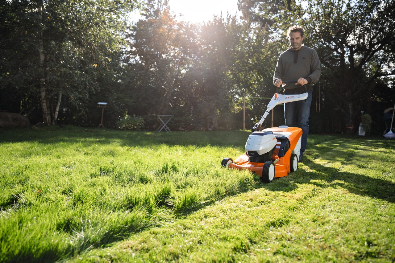 Man maait het gazon met een accu grasmachine