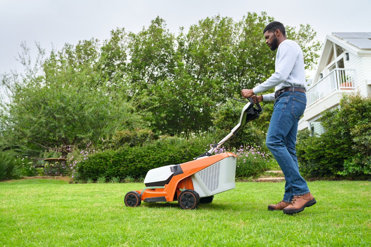 Man maait het gras met een accu grasmaaier
