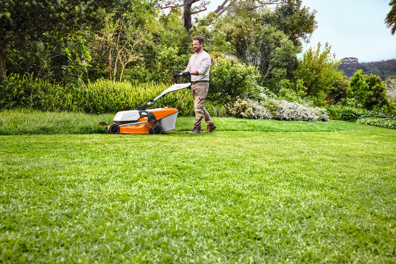 Man maait het gras met een accu grasmaaier