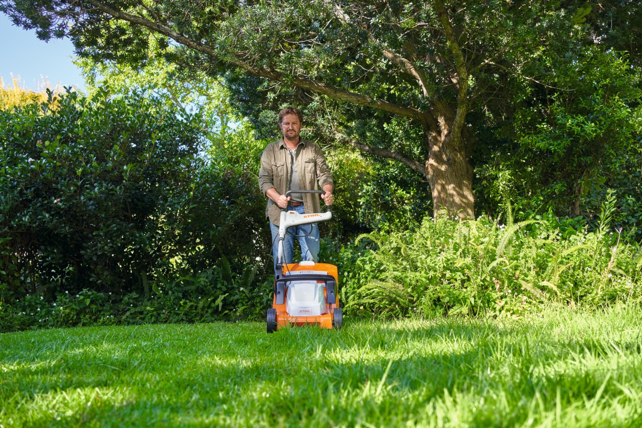 Man maait het gras met een elektrische grasmaaier