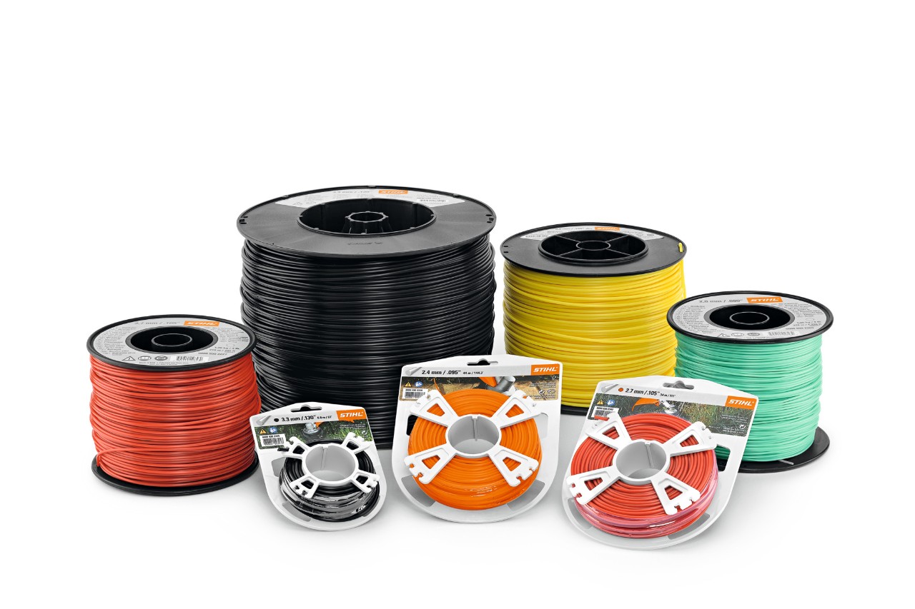 Selectie van STIHL maaikoorden opgerold in verschillende kleuren en diktes op een witte achtergrond.