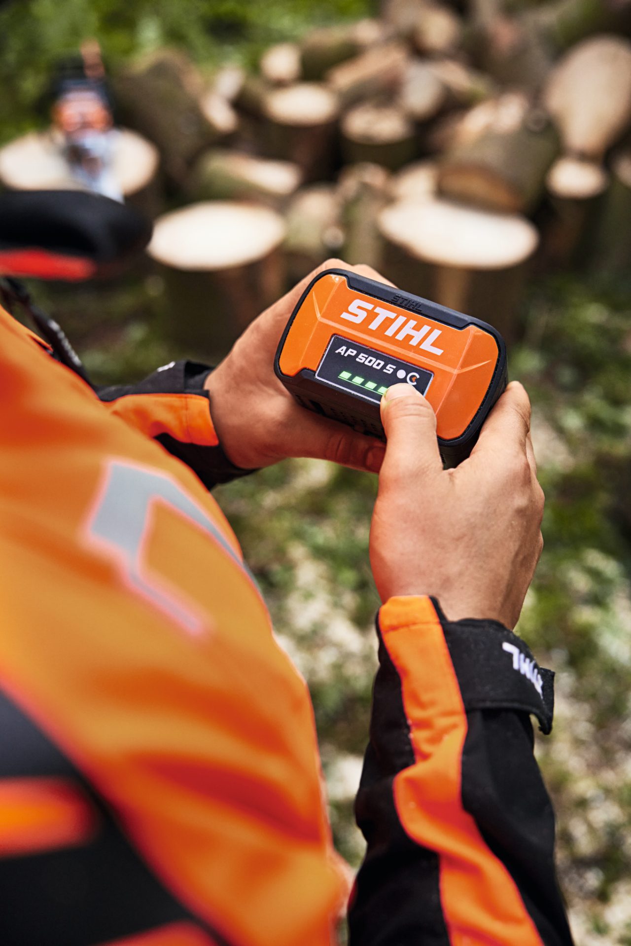 Close-up van iemand die met de STIHL MSA 300 accukettingzaag een boomstam doorzaagt