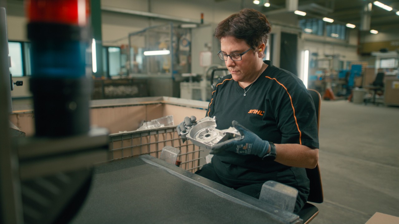 Een vrouw controleert zorgvuldig een component op gebreken en afwijkingen