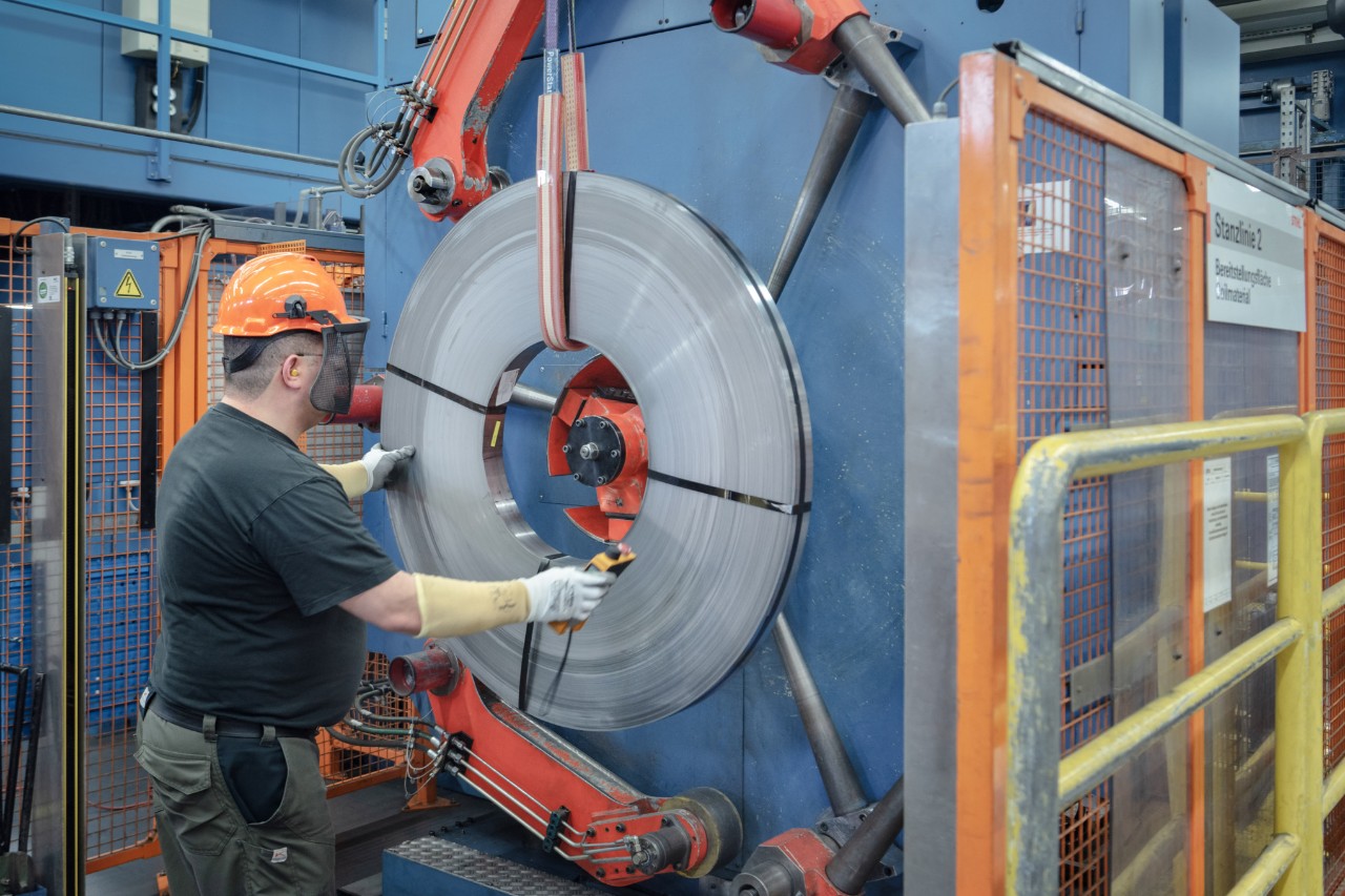 Een man in veiligheidsuitrusting werkt aan een machine voor de zaagbladproductie bij STIHL 