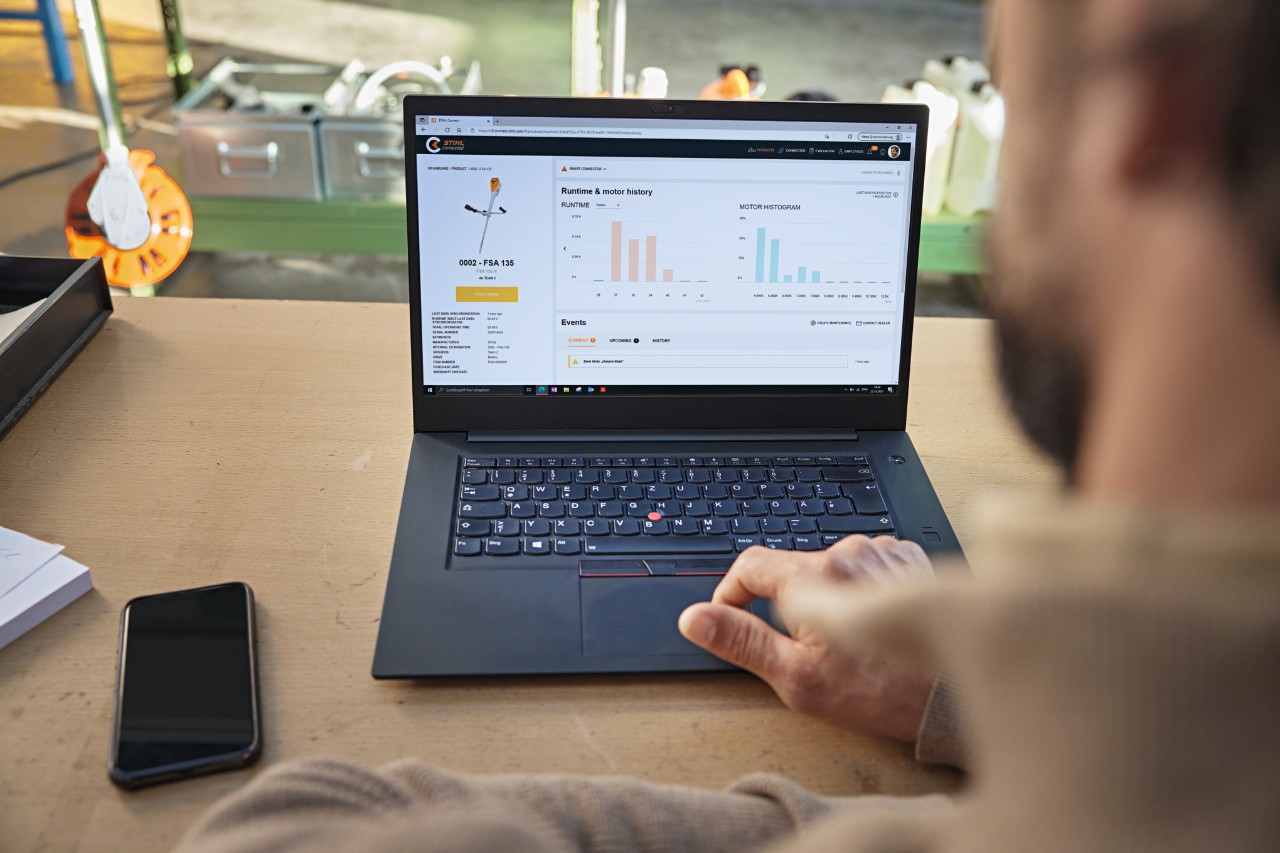 De persoon zit achter zijn computer en controleert de status van het apparaat via het STIHL connected portal