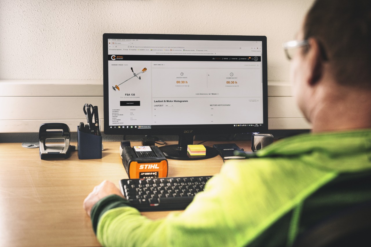 Mann sitzt vor seinem Computer und arbeitet mit dem STIHL connected Portal 