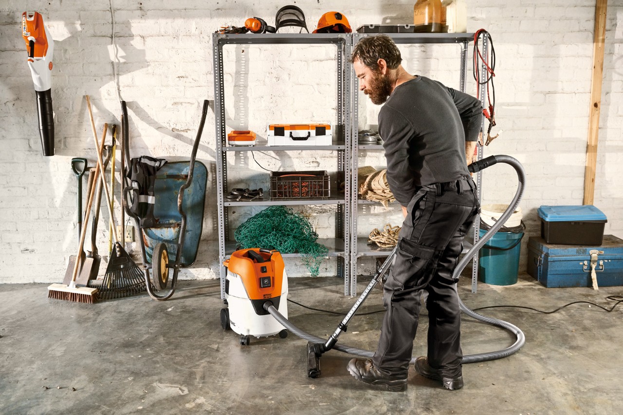 Man stofzuigt de vloer van een garage met een STIHL SE 62 E alleszuiger