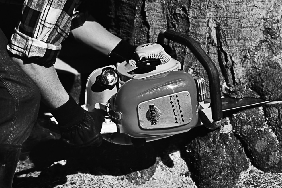 Oude zwart-wit close-up van iemand die een boom velt met behulp van de STIHL Contra kettingzaag