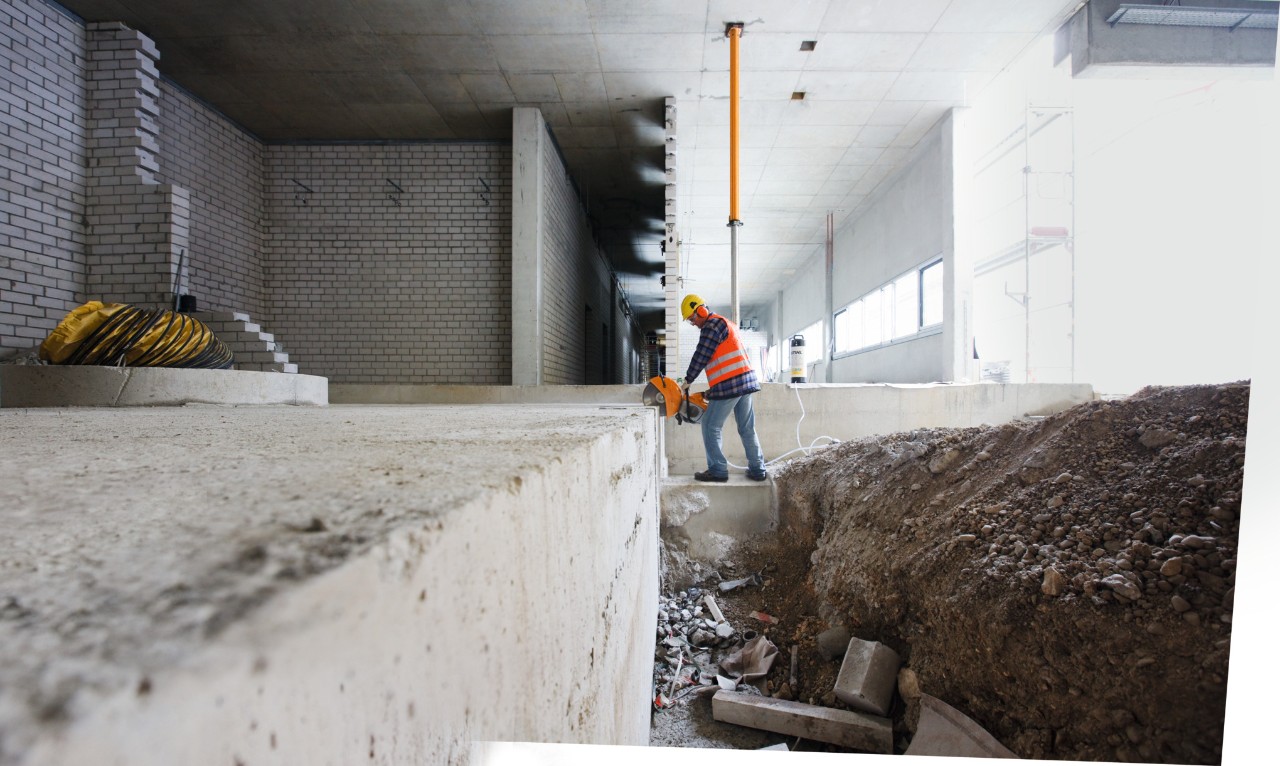 Een man met een STIHL TS 500i benzinedoorslijper snijdt een stalen bout in stukken op een bouwplaats