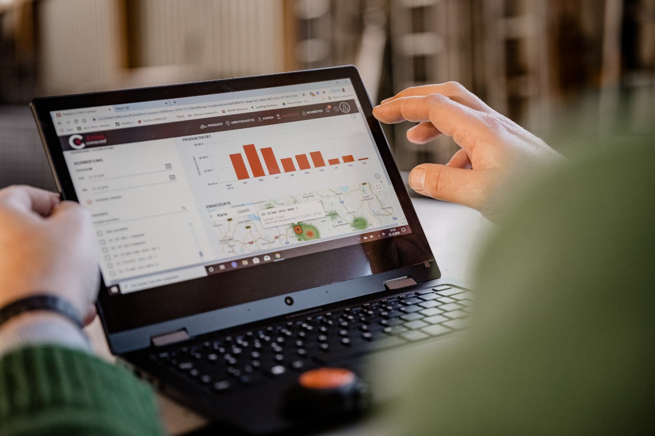 Man houdt een notebook met STIHL connected vast