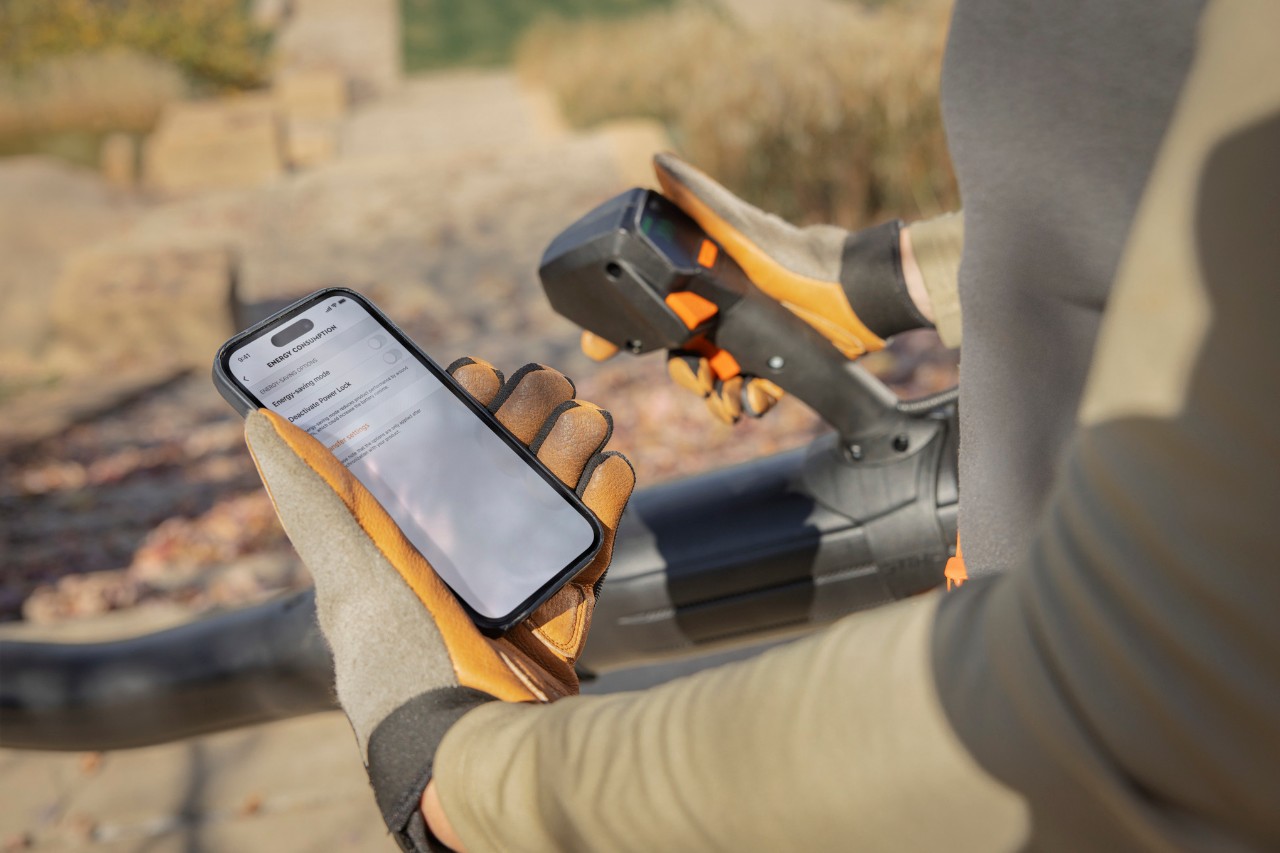 Tuinman met bladblazer en smartphone met connected