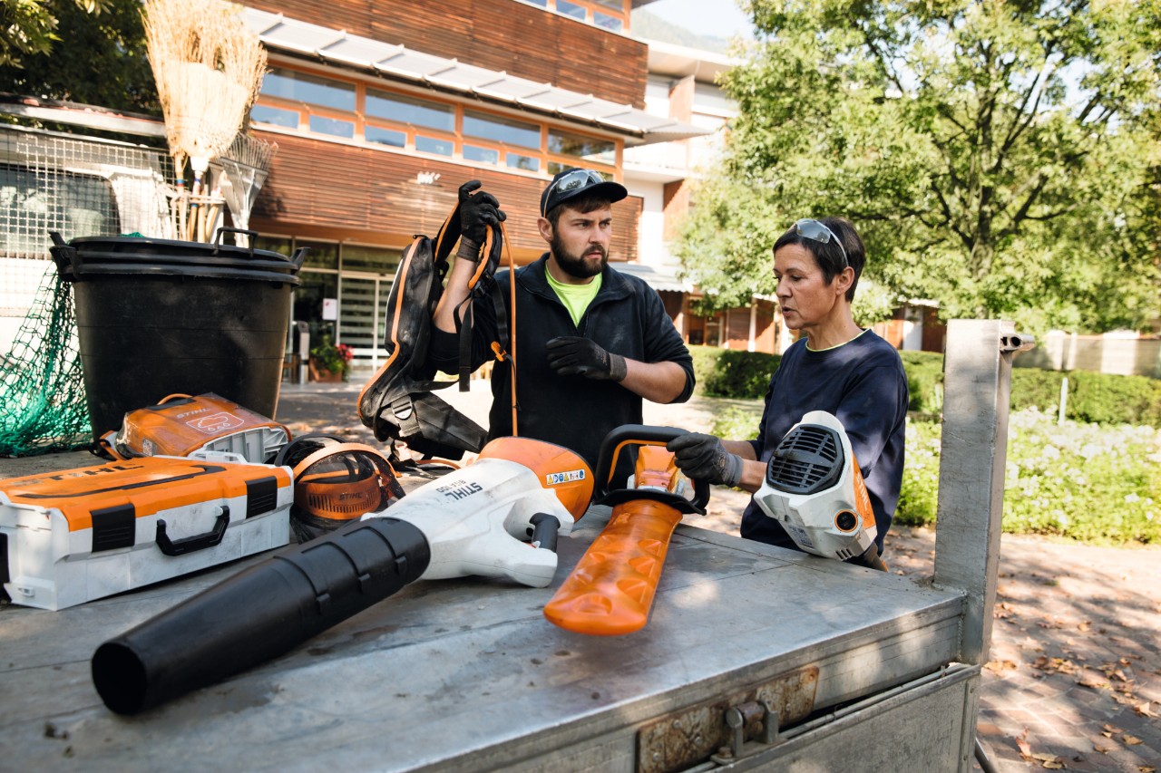 Een jonge vrouw voor een schap bij een STIHL dealer wil gratis met een STIHL kettingzaag uitproberen 