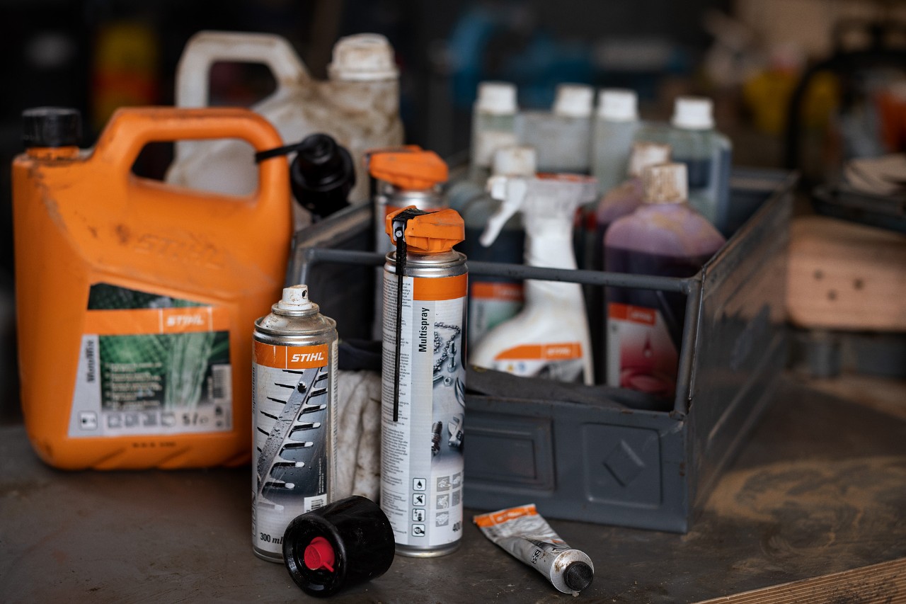 Verschillende kracht- en smeermiddelen van STIHL, sommige daarvan in een kist 
