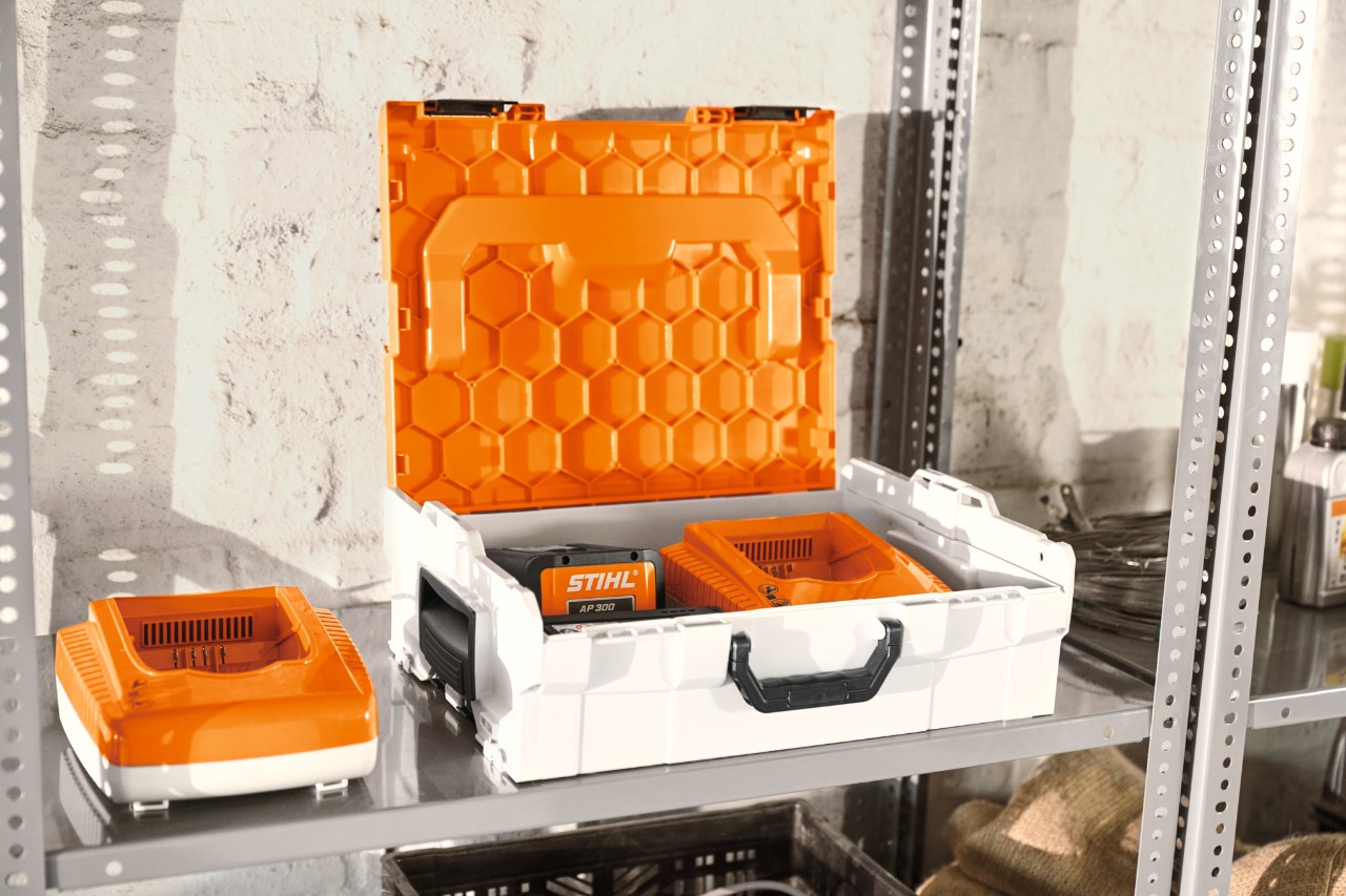 STIHL accubox met STIHL accu's in een rek in een werkplaats  