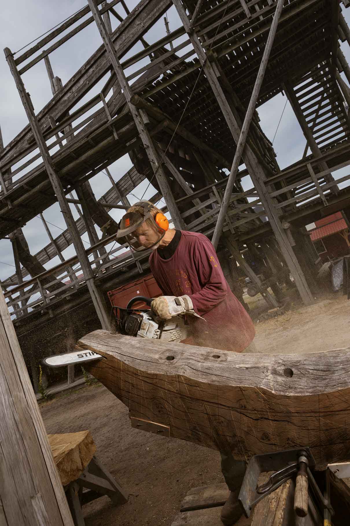 Marco zaagt een stuk hout met een kettingzaag