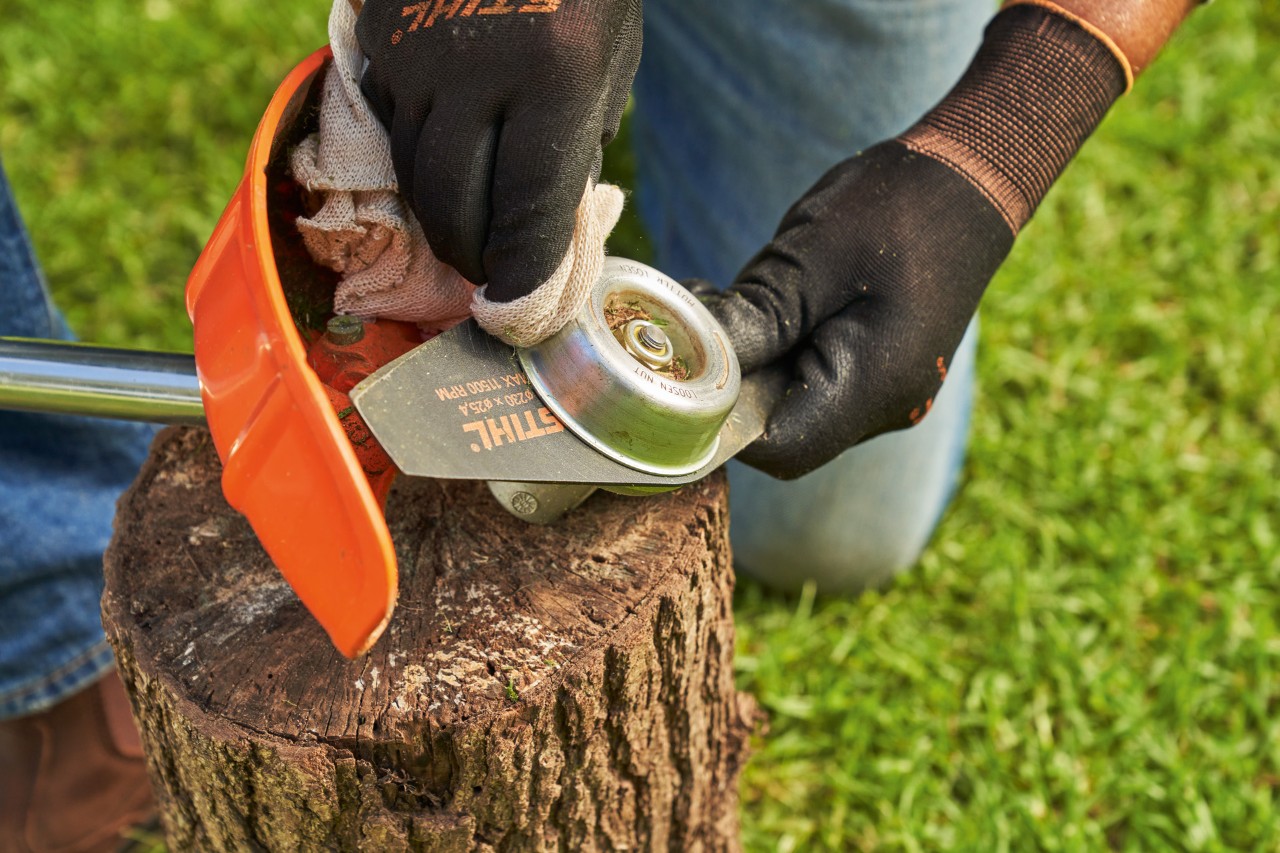 Reinig het slagmes van een STIHL grasmaaier met een vochtige doek