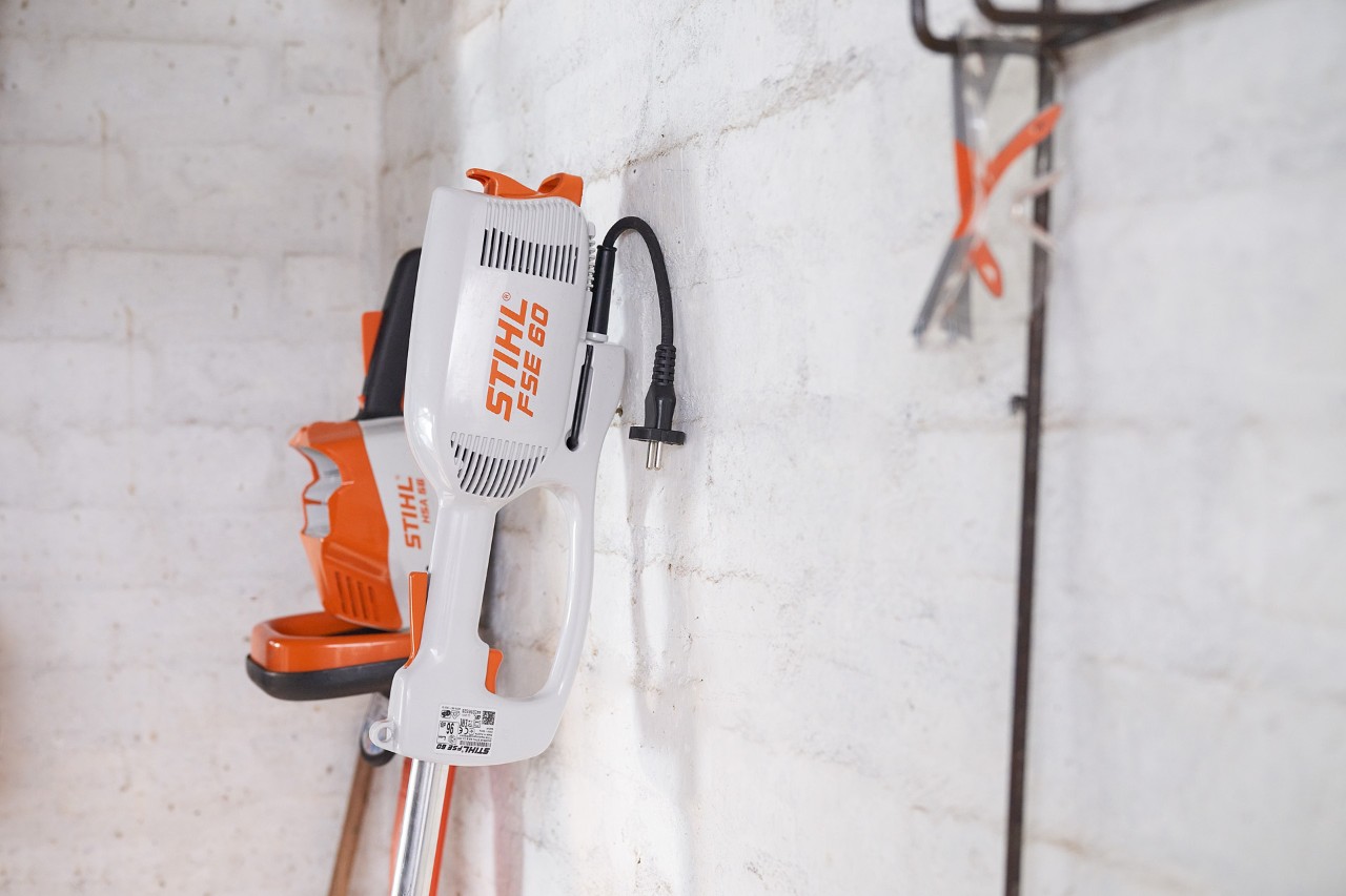 De STIHL FSE 60 elektrische kantenmaaier opgeborgen in een garage
