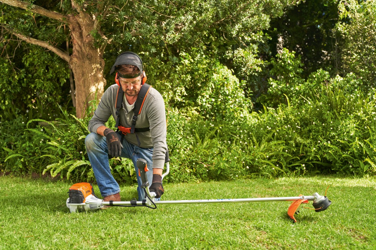 Man legt de STIHL FS 91 benzinebosmaaier op de grond om deze te starten