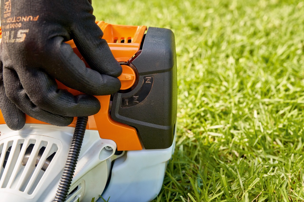Man drukt de hendel van de brandstofpomp van de STIHL FS 91 benzinebosmaaier in om deze te starten