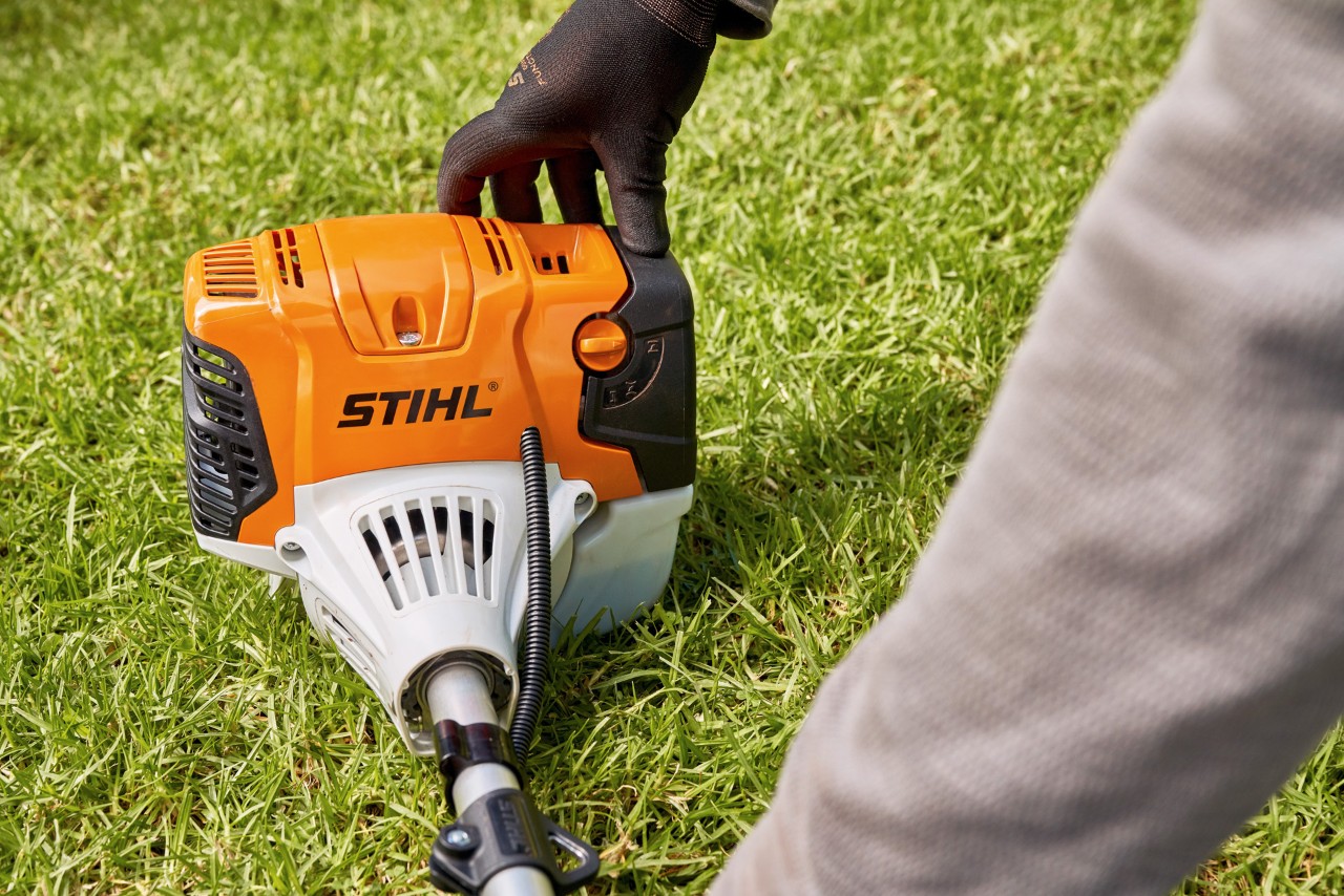Man drukt de STIHL FS 91 benzinebosmaaier stevig tegen de grond