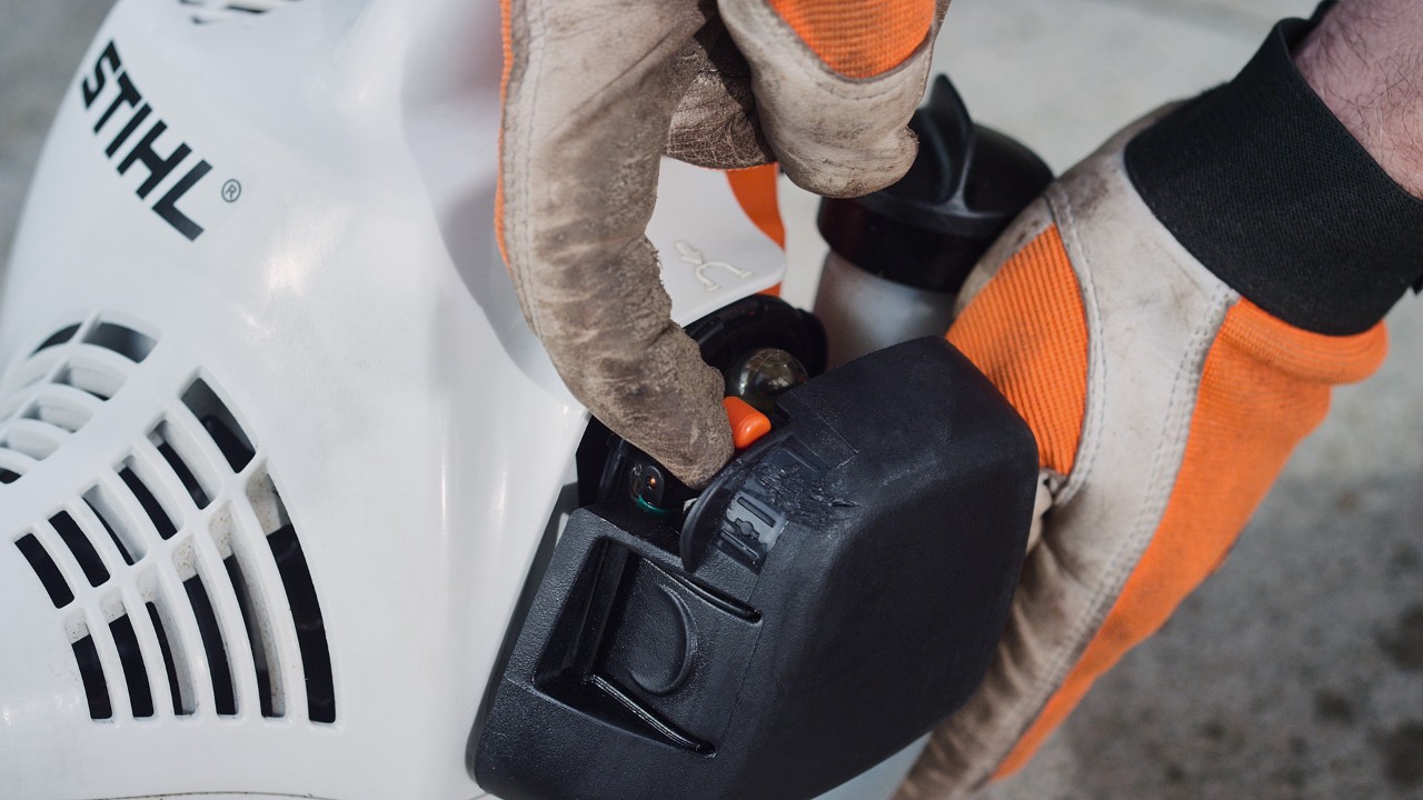 De hendel van de chokeknop op de STIHL FS 38 benzinegrastrimmer wordt bediend