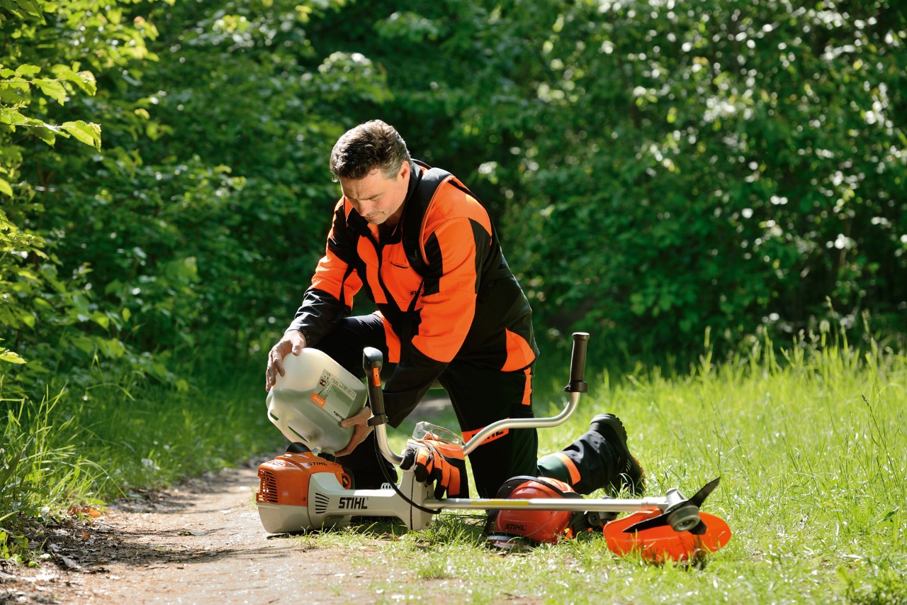 Een man vult een STIHL bosmaaier met een benzine-oliemengsel
