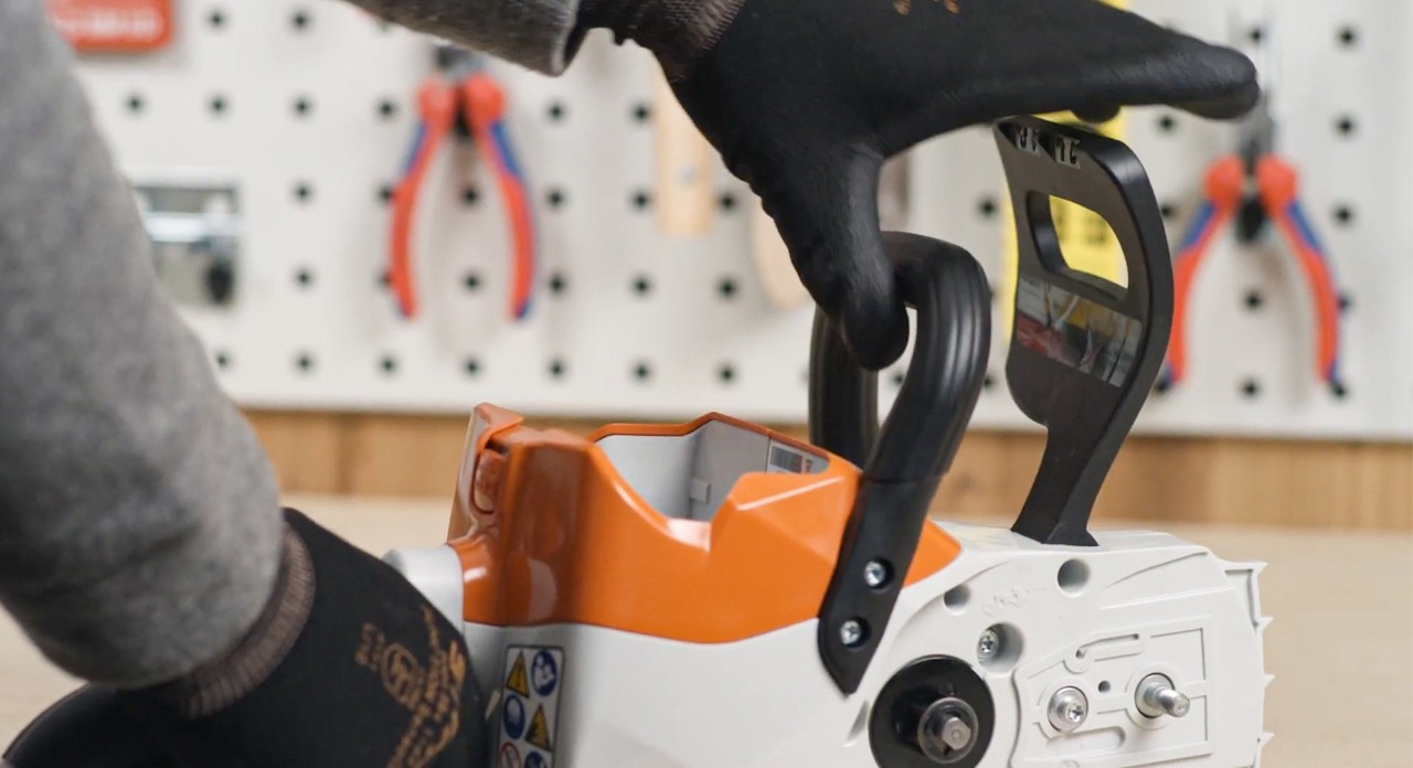 De kettingrem van een STIHL MSA 120 accukettingzaag wordt ontspannen