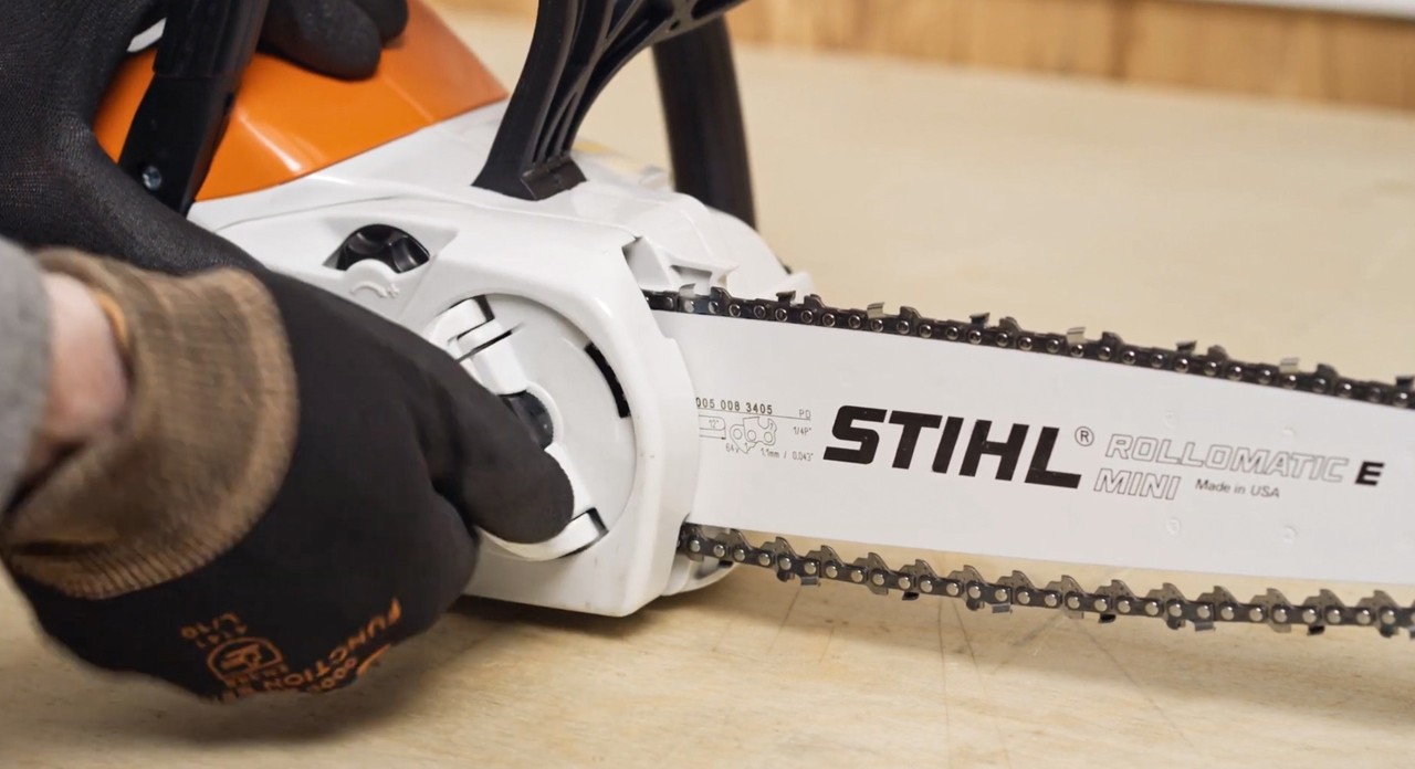 Het kettingtandwieldeksel wordt op een STIHL MSA 120 accukettingzaag gezet