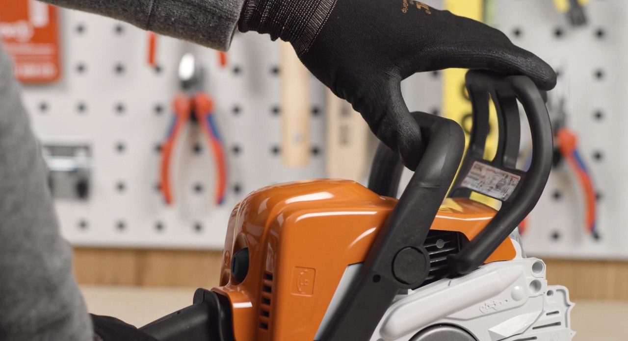 De kettingrem van een STIHL MS 180 kettingzaag wordt vóór het monteren ontspannen