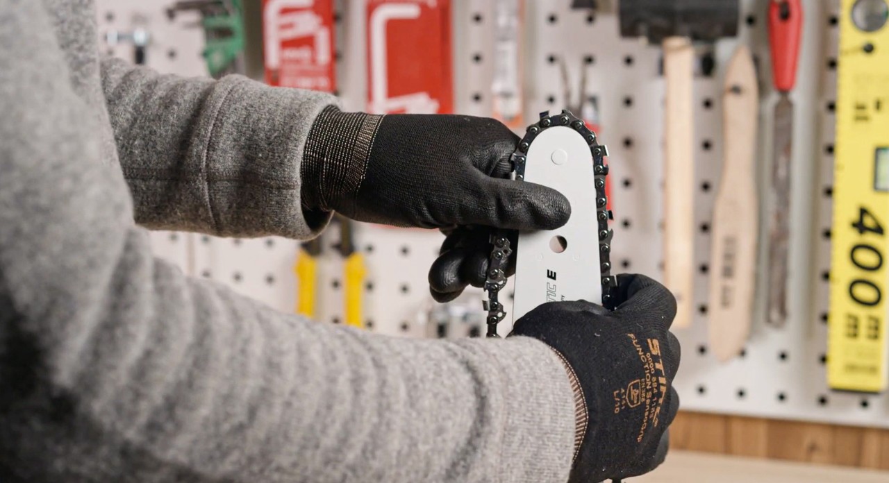 De zaagketting wordt op het zaagblad van een STIHL MS 180 kettingzaag gelegd