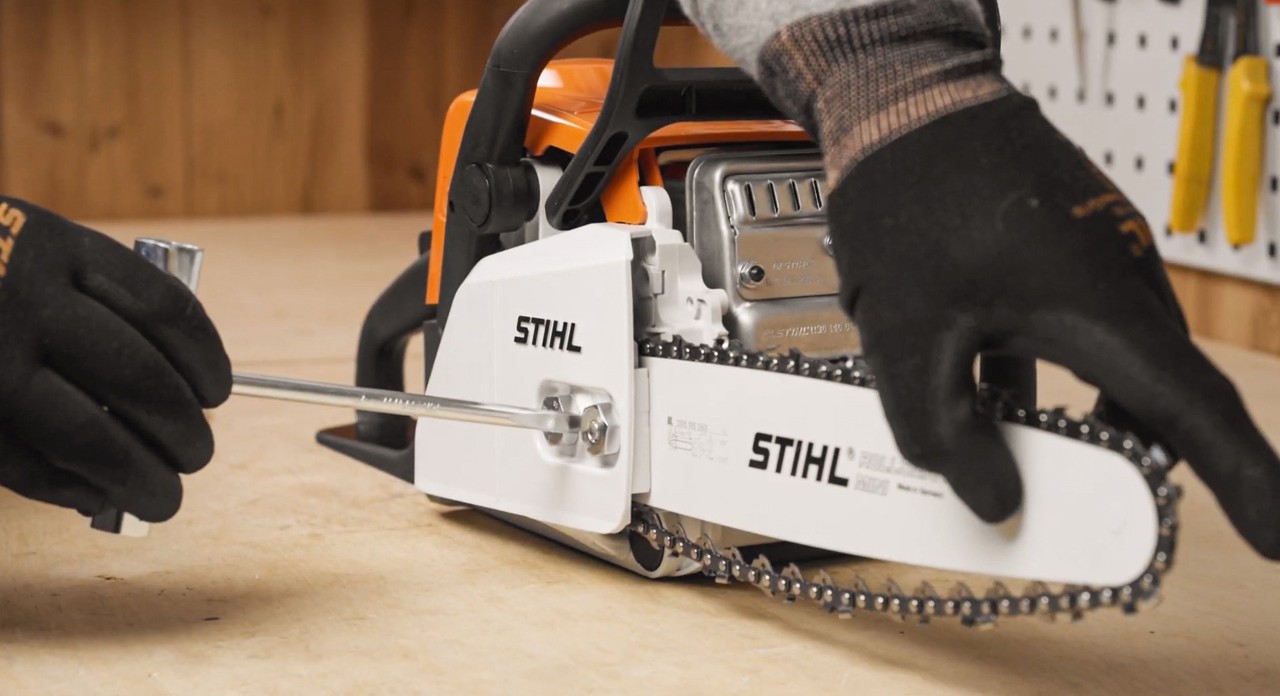 De zaagketting van een STIHL MS 180 kettingzaag wordt na het monteren aangespannen