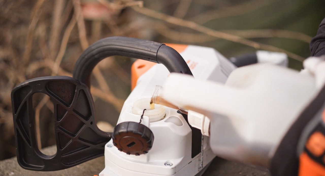 Na het monteren wordt een STIHL MSA 120 accukettingzaag gevuld met zaagkettingolie