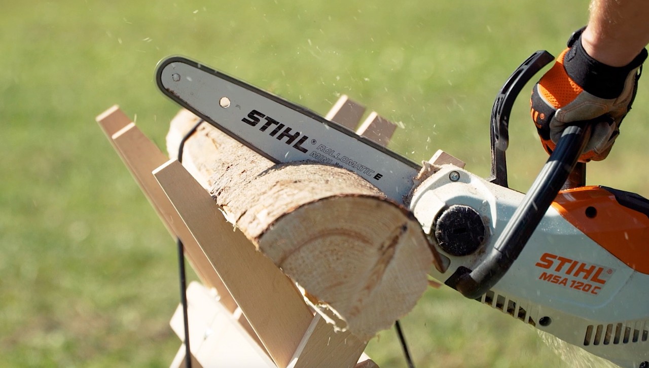 STIHL Met de accukettingzaag MSA 120 C wordt een stuk hout op een zaagbok tot brandhout gezaagd. 