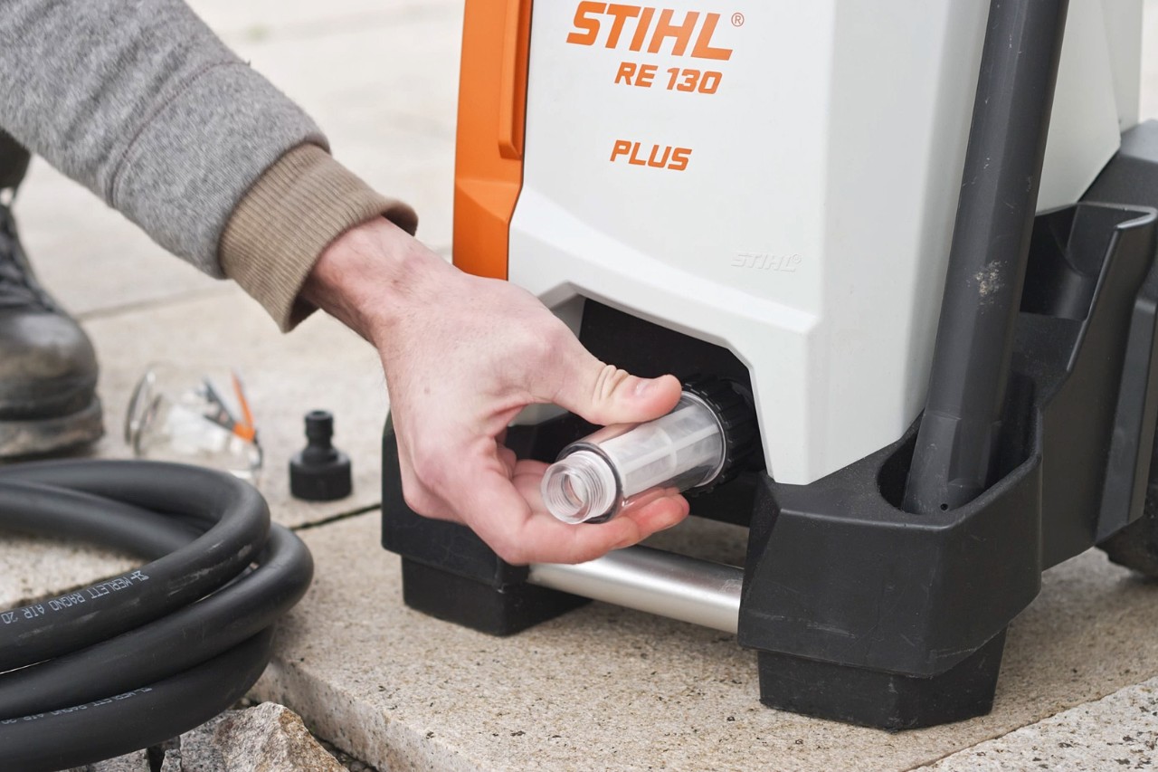 Iemand controleert de aansluiting van de hogedrukreiniger STIHL RE 130 PLUS