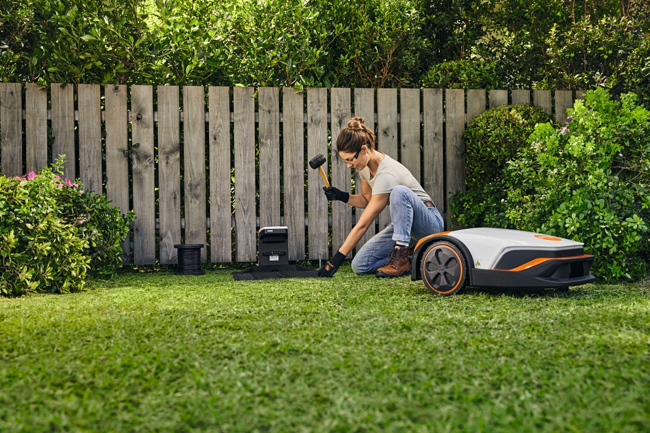 Een vrouw installeert een iMOW® robotmaaier