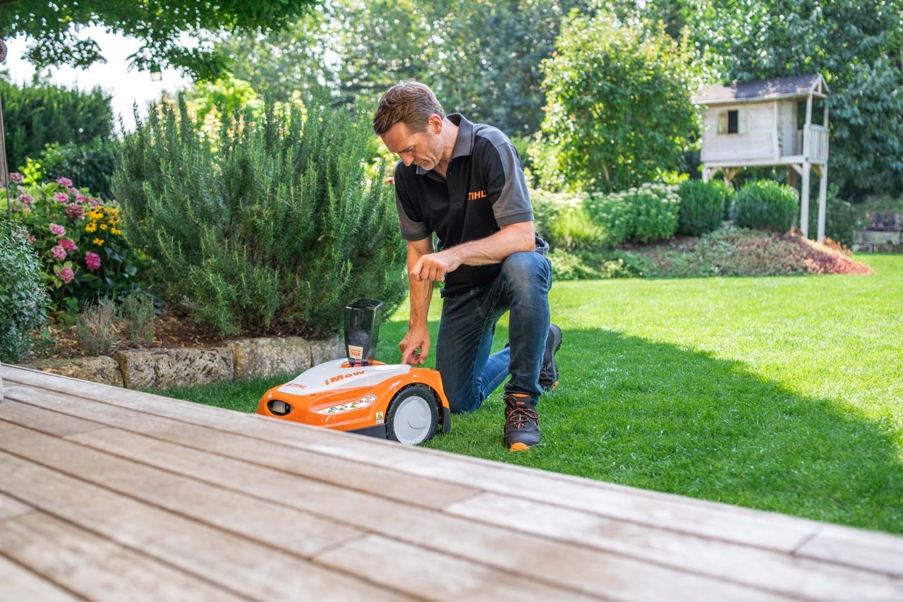 A STIHL dealer sets the dynamic mowing plan of a STIHL RMI 422 iMOW® robot mower on a green lawn