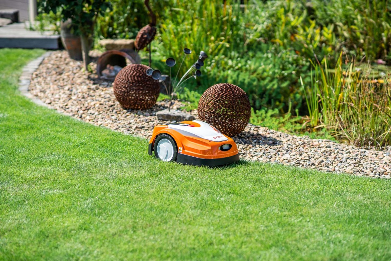 STIHL iMOW® robotmaaier op zijn zij gekanteld, vóór reiniging