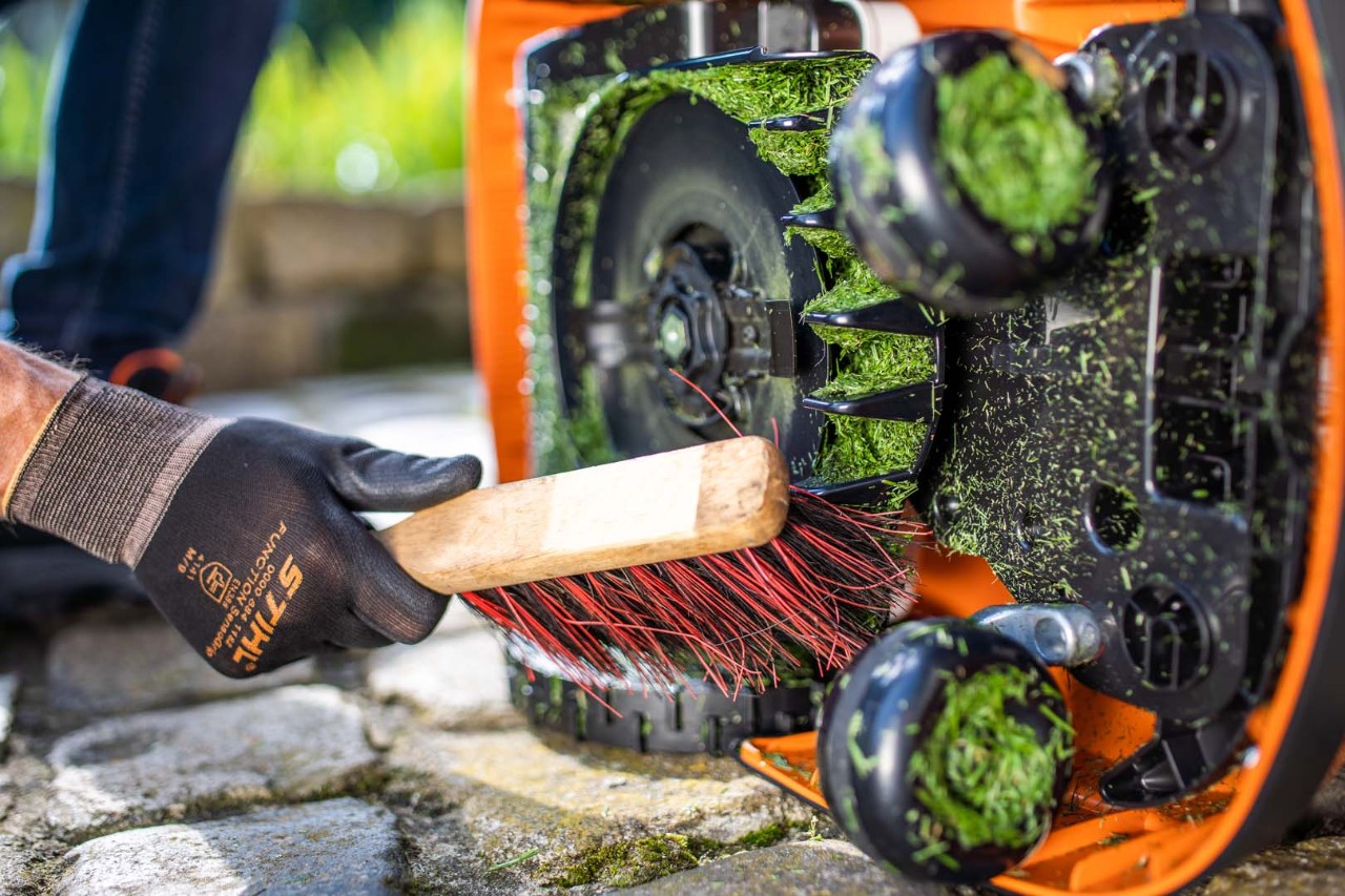 Het maaimes van een STIHL iMOW® 422 robotmaaier worden gereinigd met een borstel