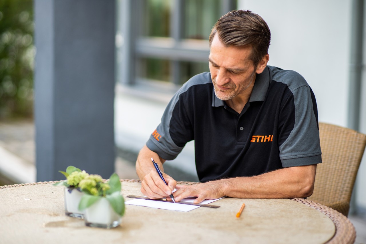 STIHL dealer tekent een plattegrond voor de installatie van een STIHL iMOW® 422 robotmaaier.