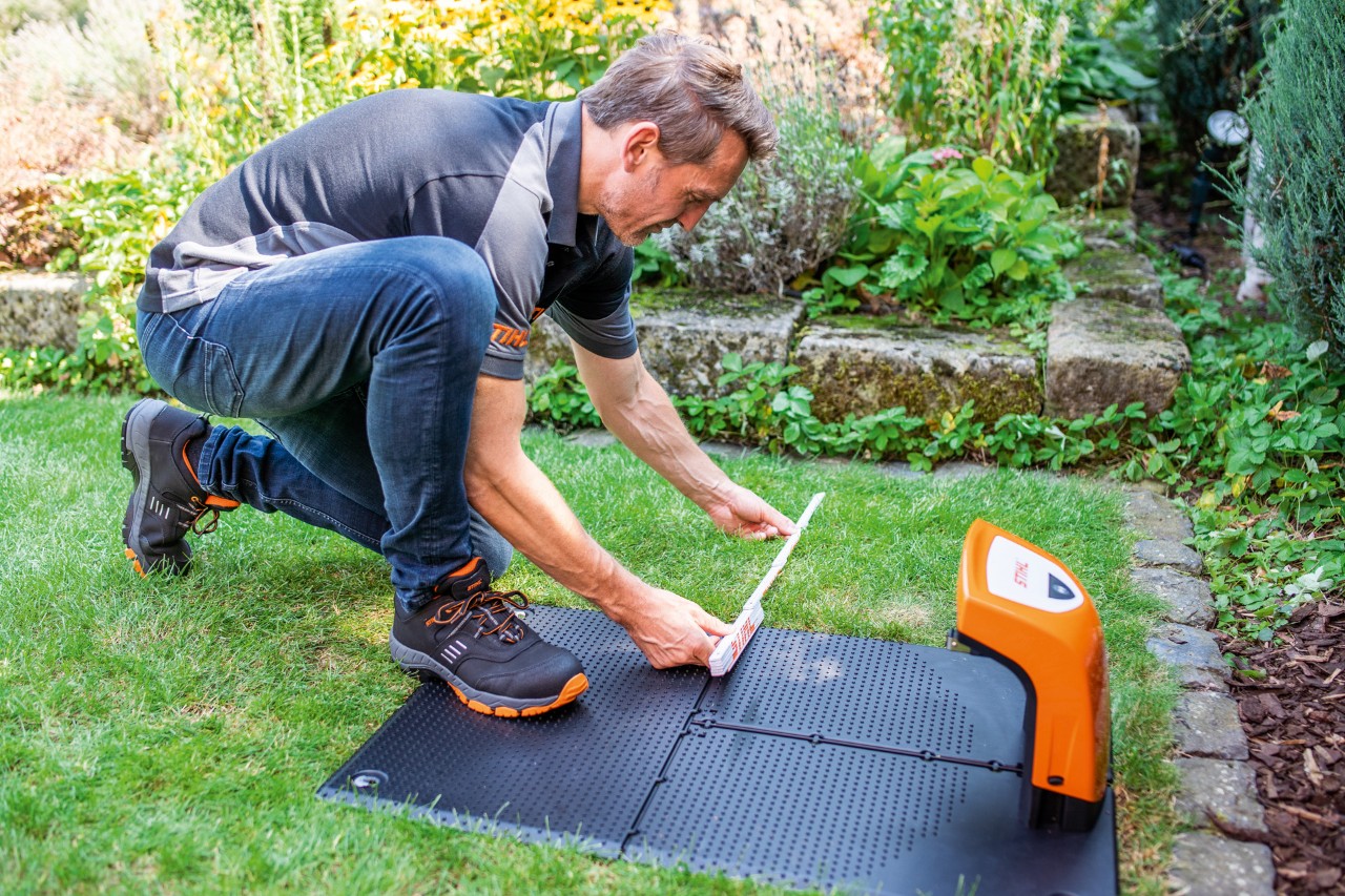 STIHL dealer monteert het dockingstation van een STIHL iMOW® 422 robotmaaier