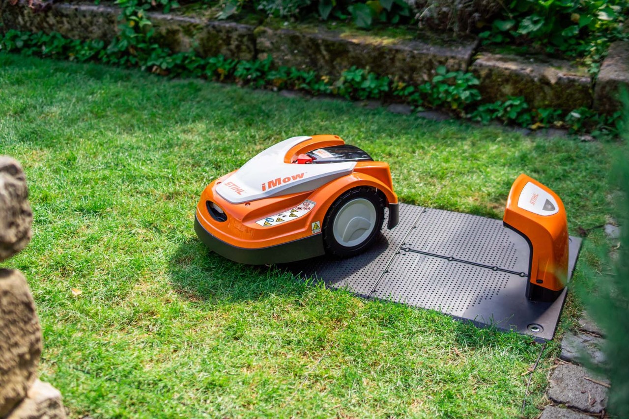 STIHL iMOW® 422 robotmaaier naast het dockingstation op groen gazon