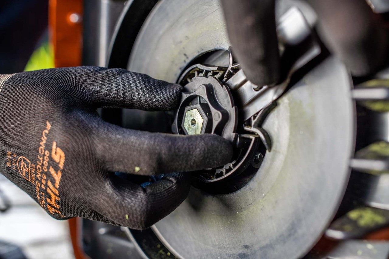 Close-up van de onderkant van de STIHL iMOW® robotmaaier tijdens het monteren
