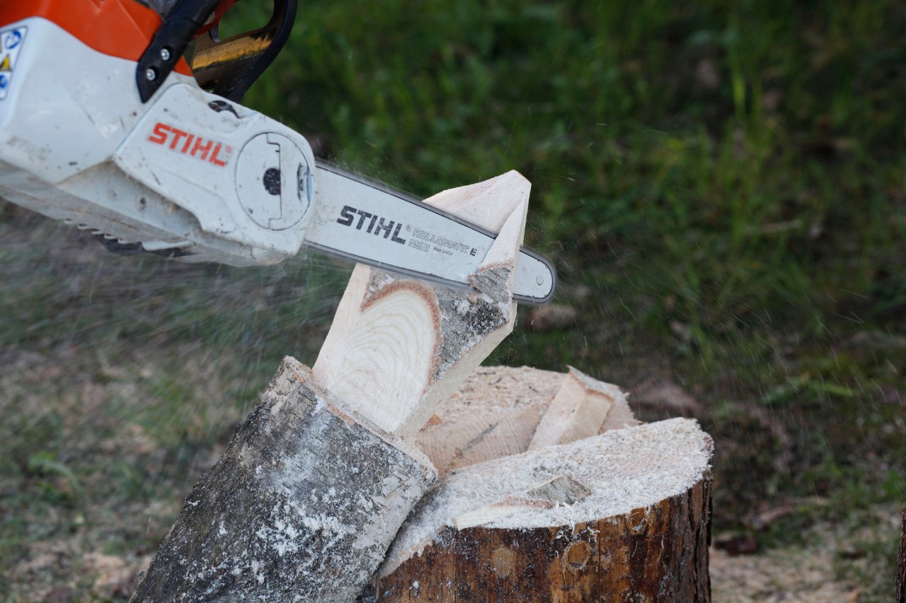 Een STIHL MSA 140 C accukettingzaag die wordt gebruikt om details toe te voegen aan een houten vlam op een boomstam