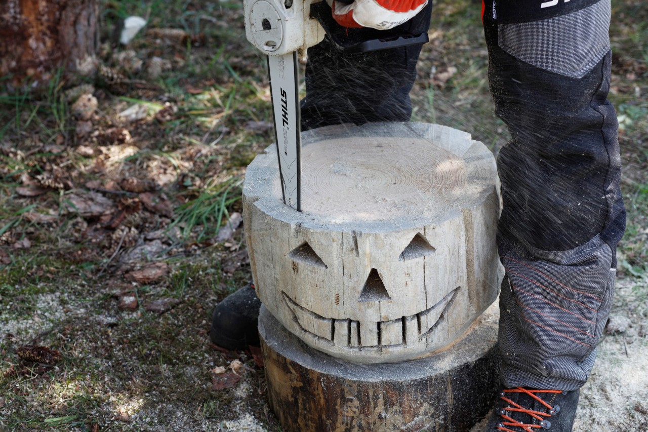 Een STIHL MSA 140 C kettingzaag wordt gebruikt om het midden van een houten pompoen te zagen.
