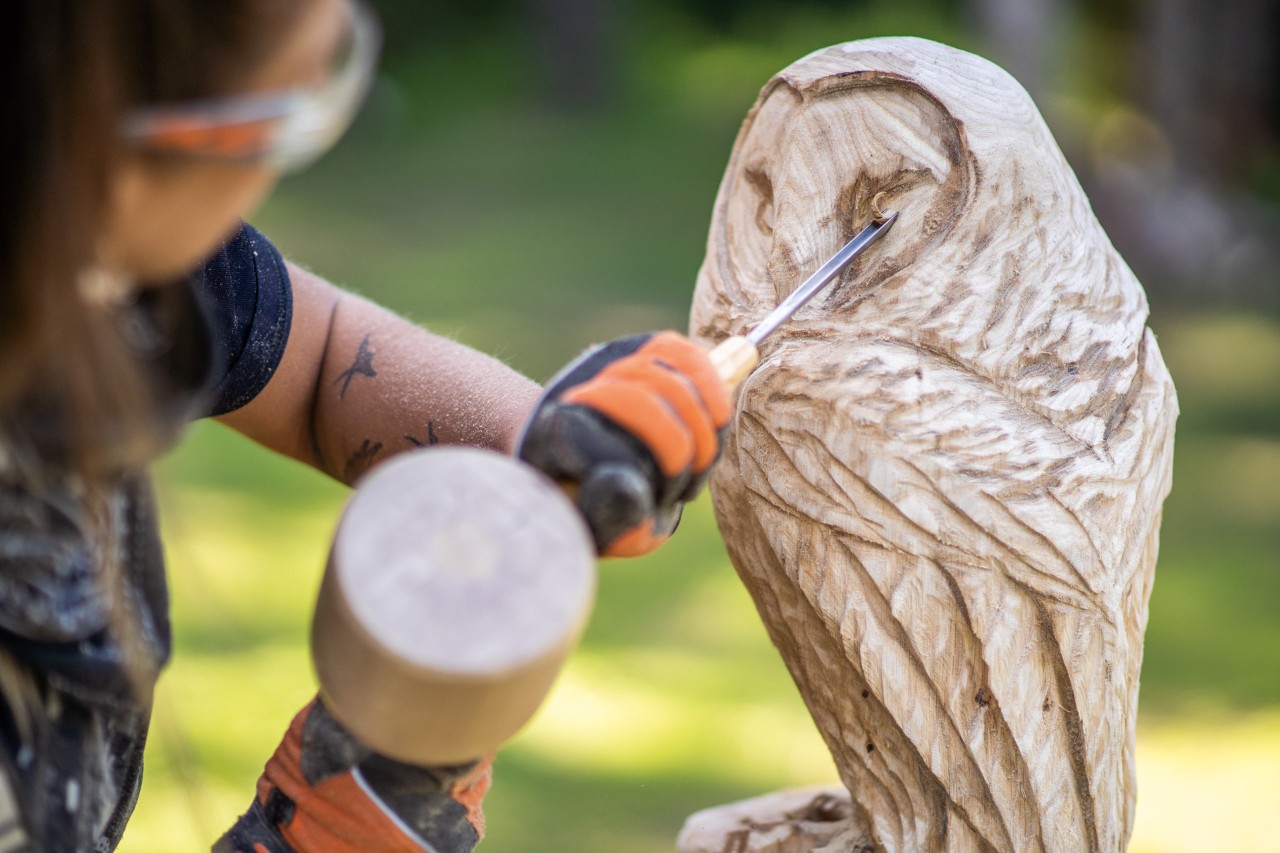 De details van de houten uil worden uitgewerkt met een steekbeitel